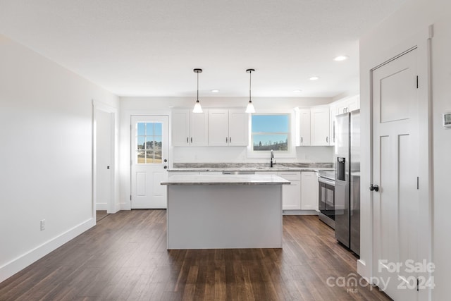 kitchen featuring a center island, plenty of natural light, hanging light fixtures, and dark wood-type flooring