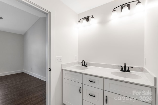 bathroom with wood-type flooring, vanity, and vaulted ceiling