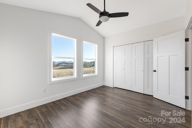 unfurnished bedroom featuring ceiling fan, a closet, dark wood-type flooring, and vaulted ceiling