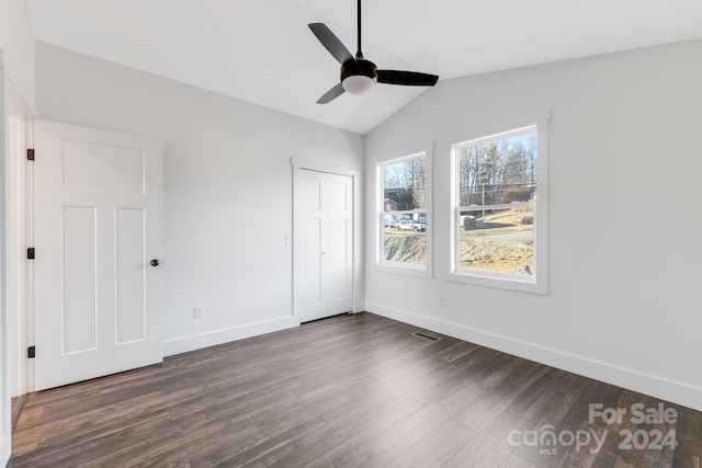 unfurnished bedroom with lofted ceiling, ceiling fan, a closet, and dark hardwood / wood-style floors