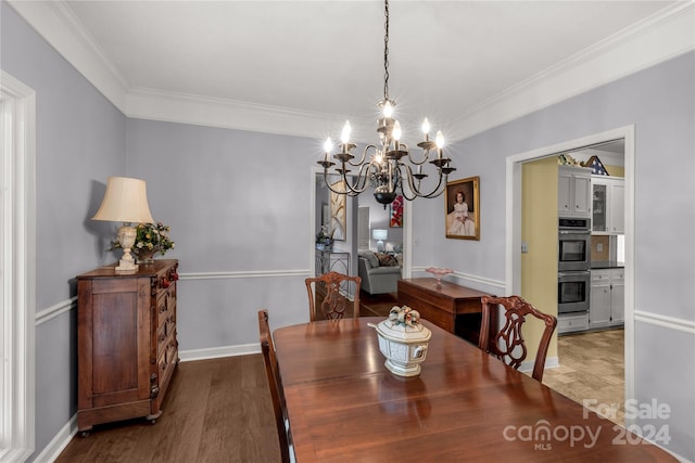 dining space with hardwood / wood-style floors, a notable chandelier, and ornamental molding