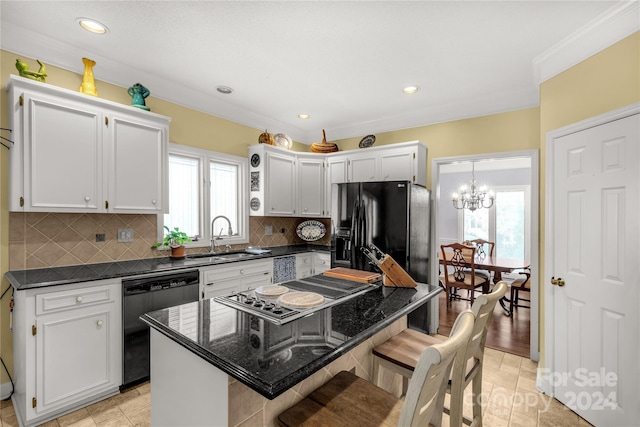 kitchen featuring appliances with stainless steel finishes, white cabinetry, a kitchen island, and a healthy amount of sunlight