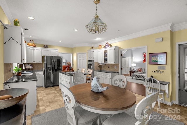 dining room featuring a notable chandelier, crown molding, and sink