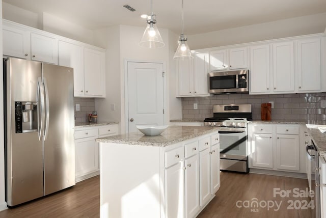 kitchen with white cabinetry, a center island, dark wood-type flooring, backsplash, and appliances with stainless steel finishes