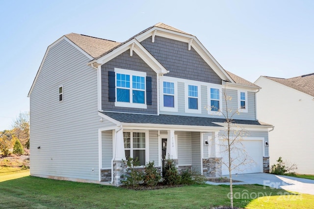 craftsman-style home with covered porch, a garage, and a front lawn