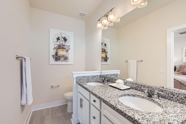 bathroom with wood-type flooring, vanity, and toilet