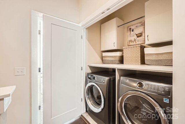 laundry room with washer and dryer and cabinets