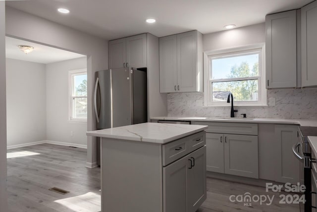 7704 Cedar Bluff Ln, Charlotte, NC 28227 - kitchen with light wood-type flooring, a center island, gray cabinets, and sink