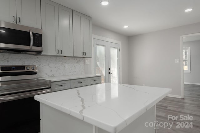 7704 Cedar Bluff Ln, Charlotte, NC 28227 - kitchen with french doors, light hardwood / wood-style flooring, light stone countertops, a kitchen island, and stainless steel appliances