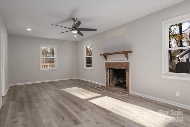 7704 Cedar Bluff Ln, Charlotte, NC 28227 - unfurnished living room featuring plenty of natural light, ceiling fan, wood-type flooring, and a fireplace