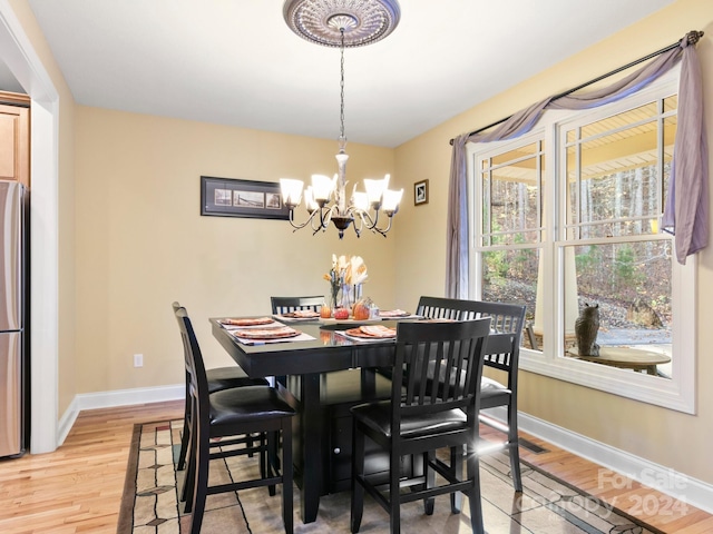 dining area featuring hardwood / wood-style flooring and an inviting chandelier