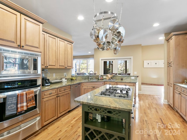 kitchen featuring kitchen peninsula, appliances with stainless steel finishes, light hardwood / wood-style flooring, and sink