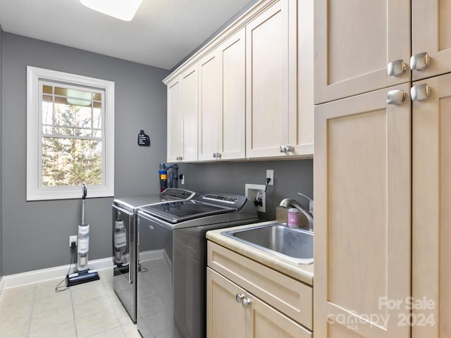 washroom featuring washer and clothes dryer, sink, light tile patterned flooring, and cabinets