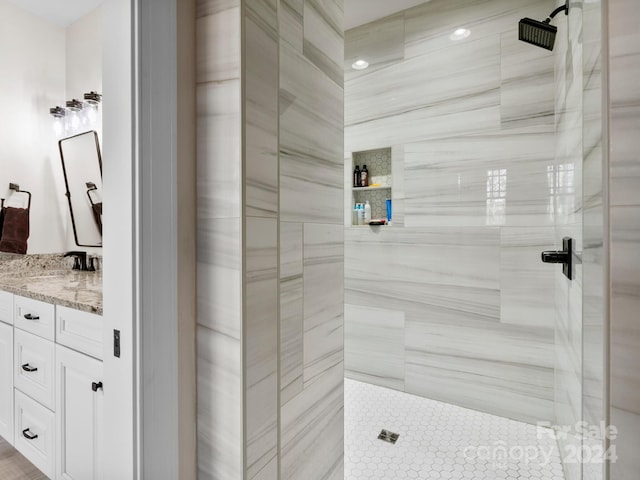 bathroom featuring a tile shower and vanity