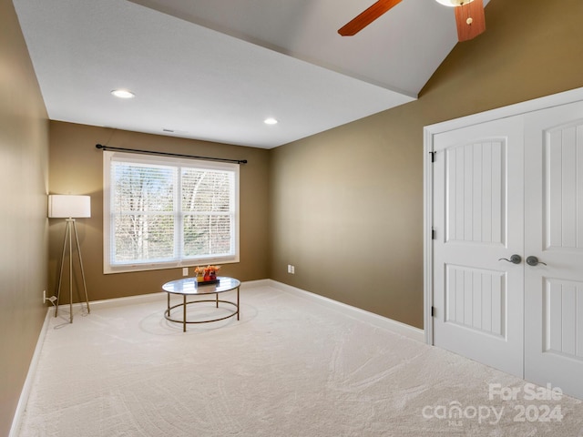 sitting room with carpet flooring, ceiling fan, and vaulted ceiling