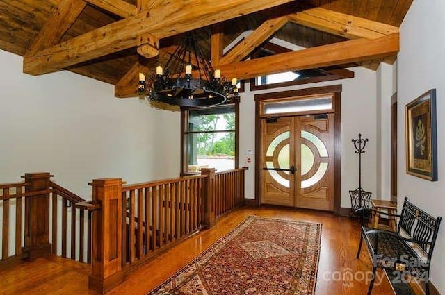 foyer entrance featuring beamed ceiling, hardwood / wood-style floors, an inviting chandelier, and wooden ceiling