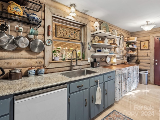 kitchen featuring dishwasher, light wood-type flooring, sink, and log walls