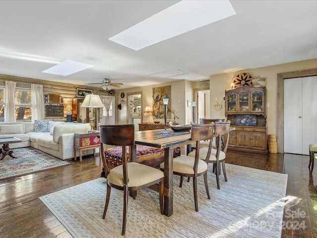 dining space featuring a skylight, ceiling fan, and wood-type flooring