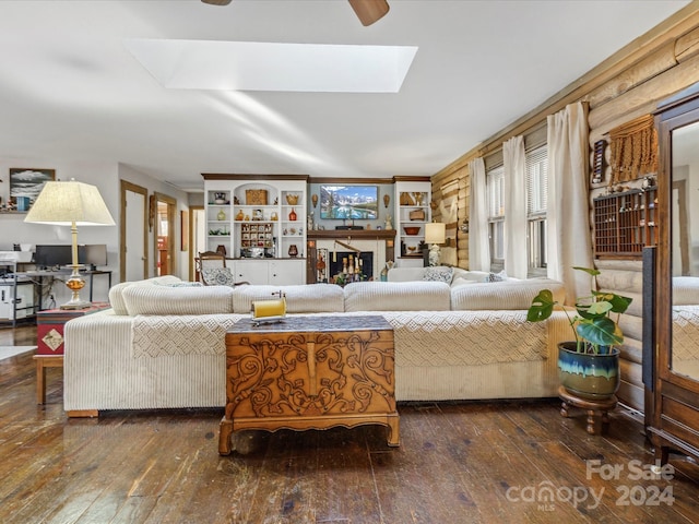 living room featuring dark wood-type flooring and a skylight