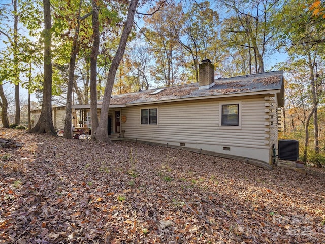 back of house with crawl space, a chimney, and central air condition unit