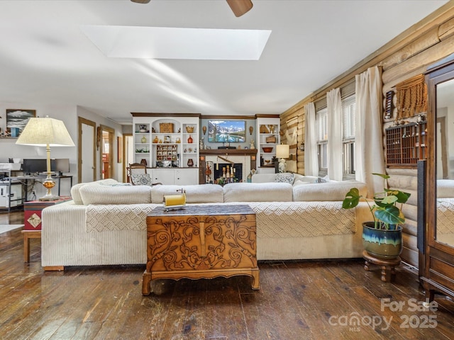 living area with hardwood / wood-style flooring and a skylight