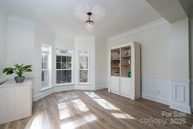 interior space with ornamental molding and hardwood / wood-style floors