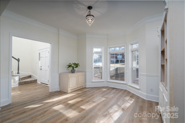 interior space featuring light wood-type flooring and crown molding