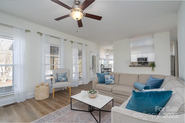 living room with light hardwood / wood-style flooring and ceiling fan