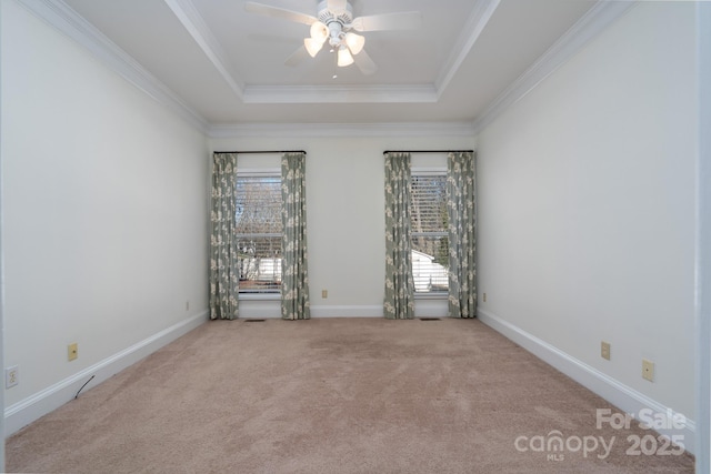 spare room featuring carpet floors, a tray ceiling, ornamental molding, and ceiling fan