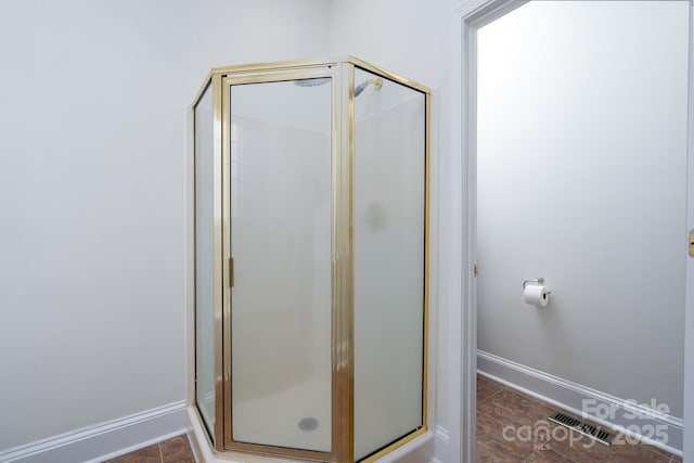 bathroom featuring an enclosed shower and tile patterned floors