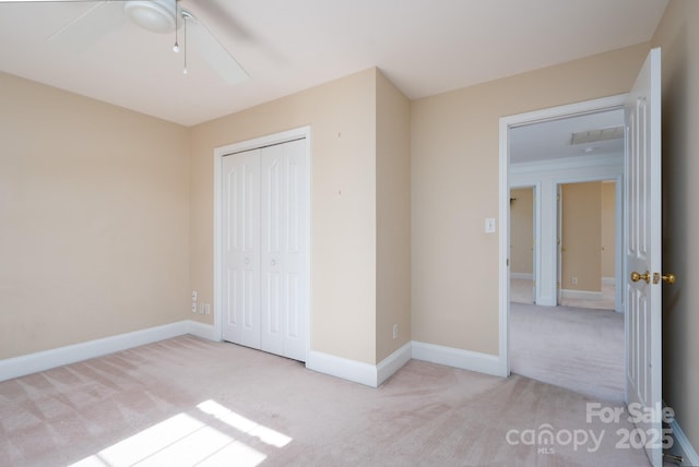 unfurnished bedroom featuring ceiling fan, light colored carpet, and a closet