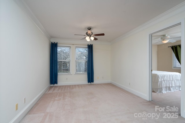 carpeted empty room featuring ceiling fan and crown molding