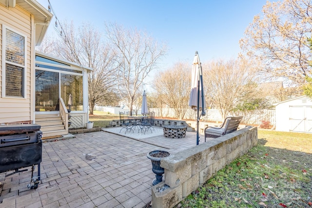 view of patio / terrace featuring a fire pit and a storage shed