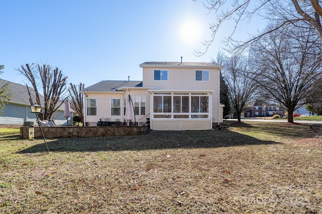 back of house featuring a yard and a sunroom