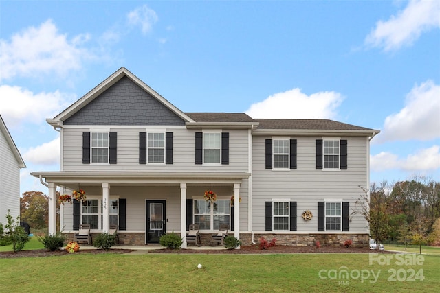 view of front facade featuring covered porch and a front yard