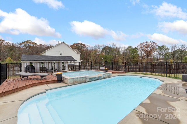 view of swimming pool with a deck and an in ground hot tub