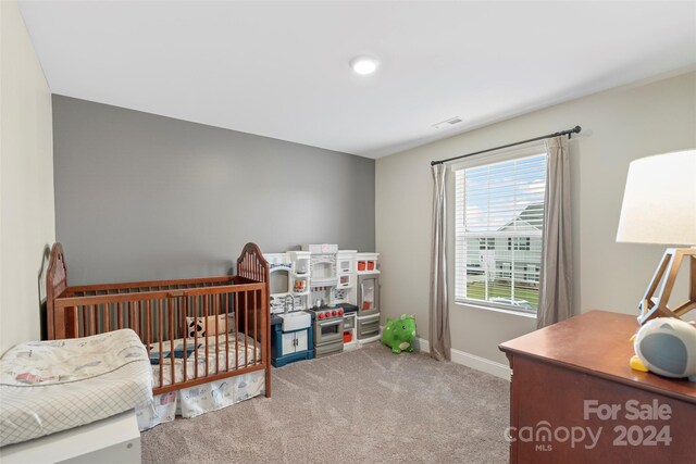 carpeted bedroom with a crib