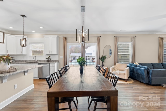 dining room featuring light hardwood / wood-style flooring, crown molding, and sink