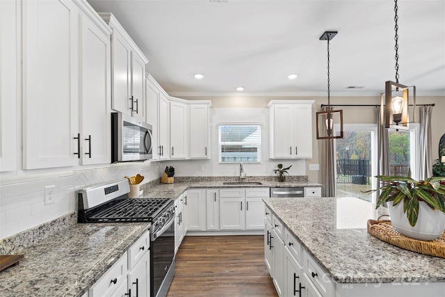 kitchen with white cabinets, pendant lighting, stainless steel appliances, and sink