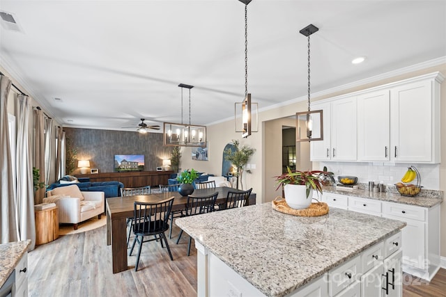 kitchen featuring white cabinetry, a kitchen island, and hanging light fixtures