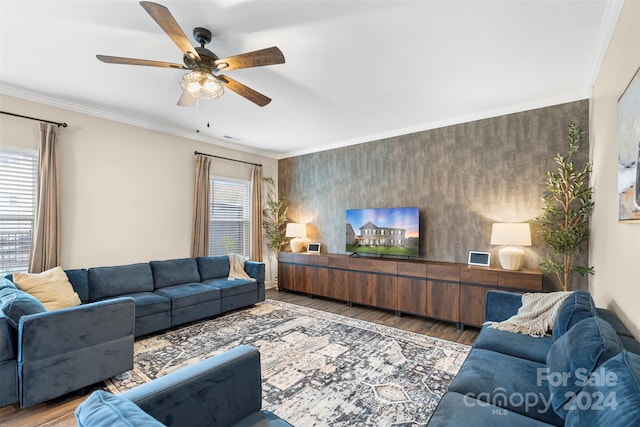 living room featuring a healthy amount of sunlight, wood-type flooring, and ornamental molding