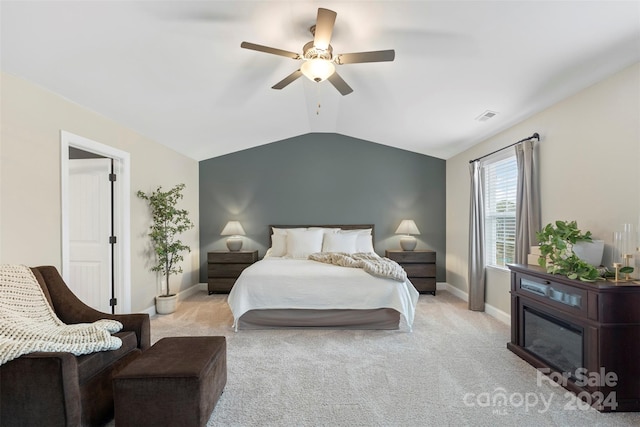 bedroom with ceiling fan, light colored carpet, and vaulted ceiling