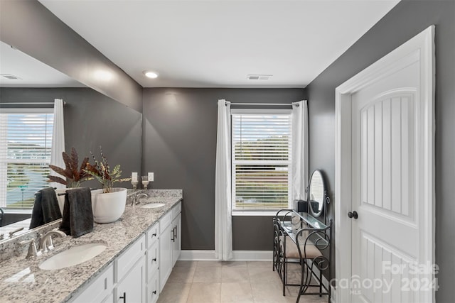 bathroom with tile patterned flooring, vanity, and a healthy amount of sunlight