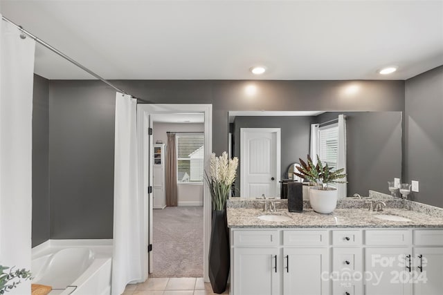 bathroom featuring a washtub, vanity, and plenty of natural light