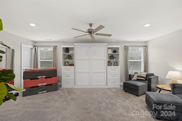 living area featuring ceiling fan and light colored carpet