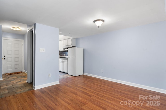 kitchen with white cabinets, dark hardwood / wood-style floors, and white refrigerator