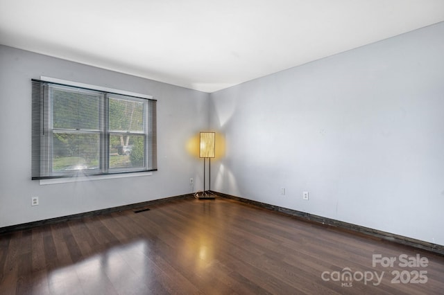 empty room with dark hardwood / wood-style floors