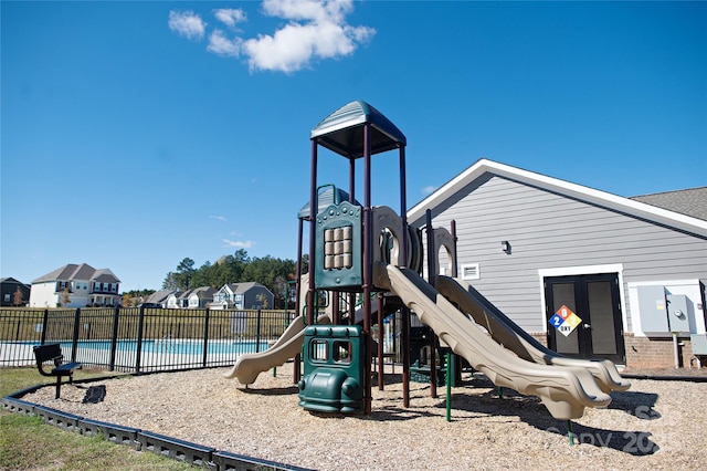 view of playground featuring a fenced in pool