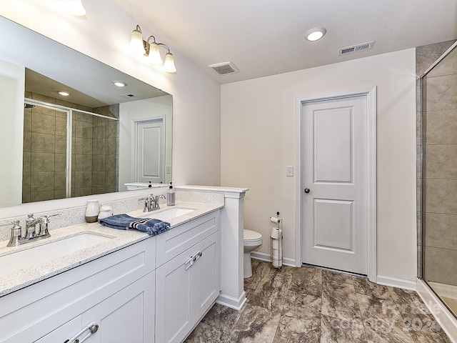 bathroom with vanity, toilet, and a shower with shower door