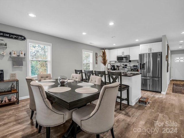 dining area with a wealth of natural light and hardwood / wood-style floors